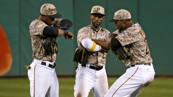 Pittsburgh Pirates left fielder Starling Marte, left, center fielder Andrew McCutchen, and right fielder Gregory Polanco celebrate a 7-2 win over the Cincinnati Reds in a baseball game Thursday, May 7, 2015, in Pittsburgh. (AP Photo/Gene J. Puskar)